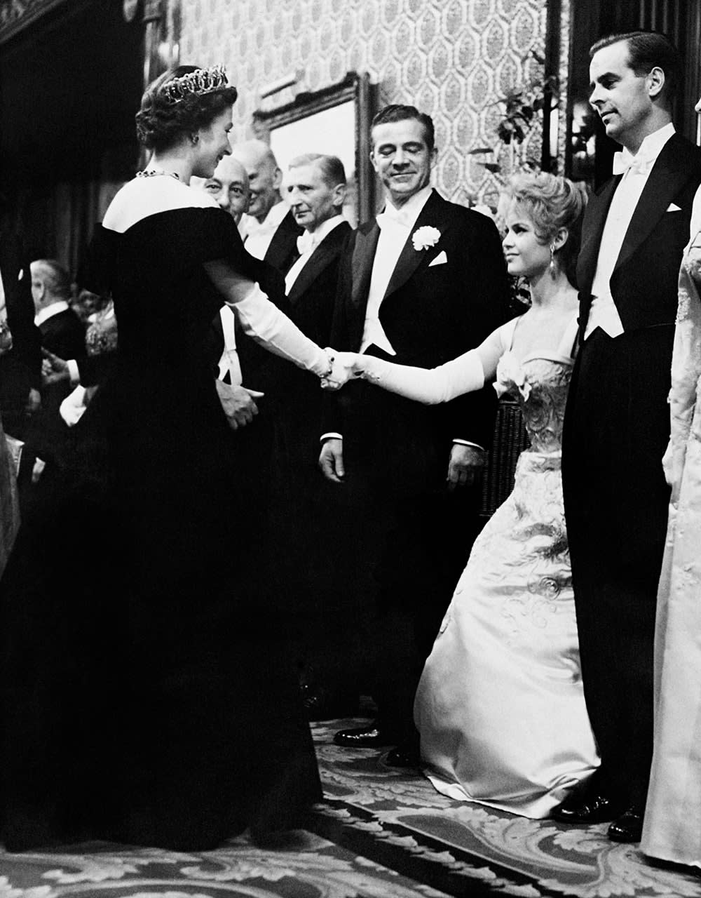 Brigitte Barfot curtsying to Queen Elizabeth II.