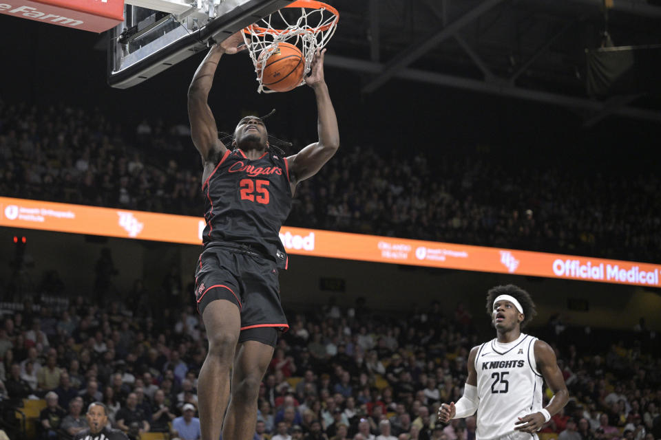 Houston forward Jarace Walker (25), left, dunks in front of Central Florida forward Taylor Hendricks (25) during the first half of an NCAA college basketball game, Wednesday, Jan. 25, 2023, in Orlando, Fla. (AP Photo/Phelan M. Ebenhack)