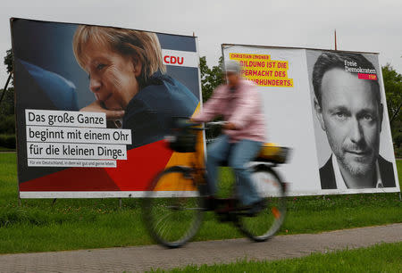 FILE PHOTO: Election campaign posters show German Chancellor Angela Merkel, a top candidate of the Christian Democratic Union Party (CDU) and the leader of the liberal Free Democratic Party (FDP) Christian Lindner in Ribnitz-Damgarten, Germany, September 8, 2017. REUTERS/Fabrizio Bensch/File Photo