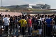 Football fans wait outside the new Corinthians Arena before the start of the Brazilian championship match between Corinthians and Figueirense on May 18, 2014