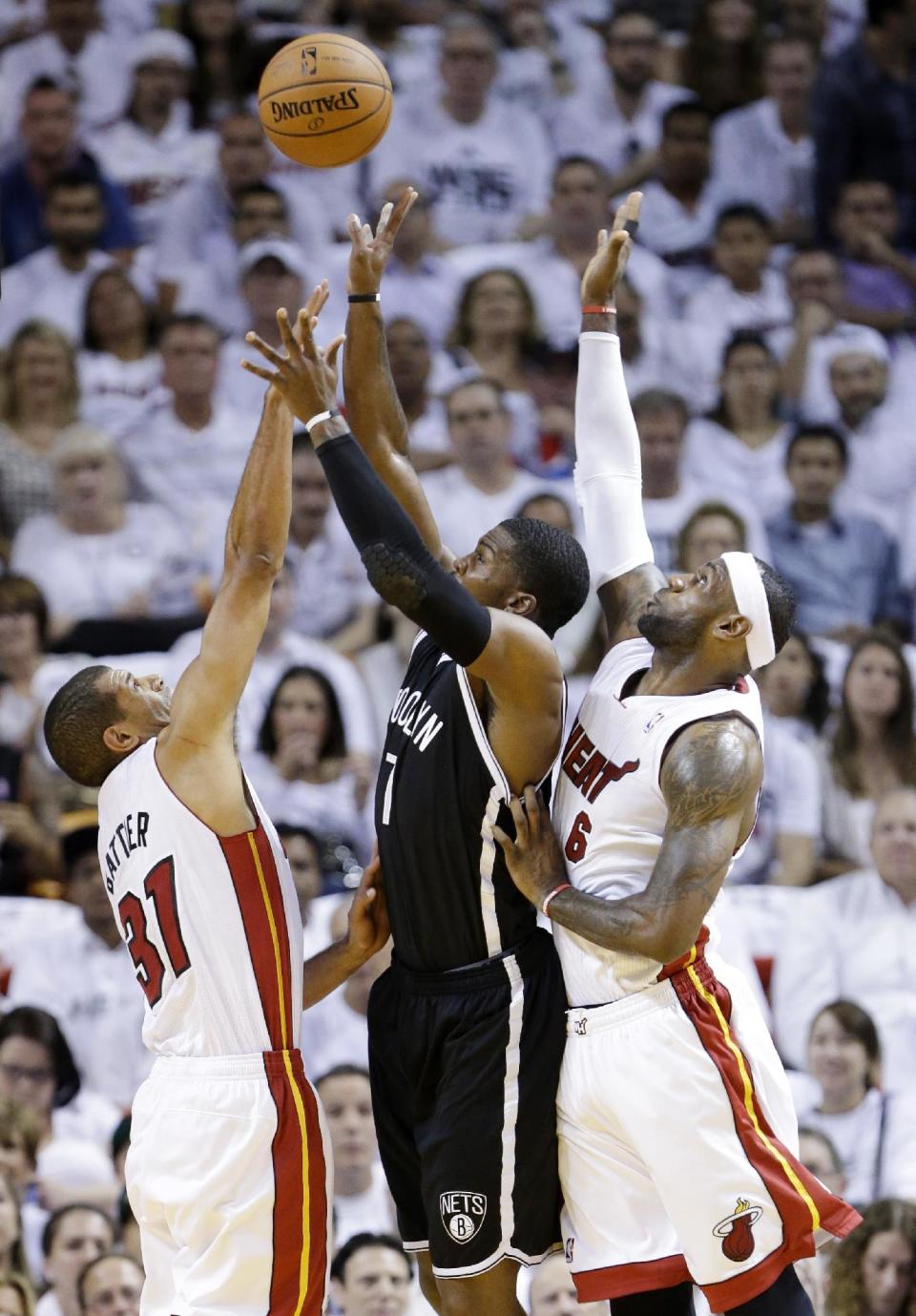 Brooklyn Nets guard Joe Johnson (7) goes up for a shot against Miami Heat forward Shane Battier (31) and forward LeBron James (6) during the first half of Game 2 of an Eastern Conference semifinal basketball game, Thursday, May 8, 2014 in Miami. (AP Photo/Wilfredo Lee)