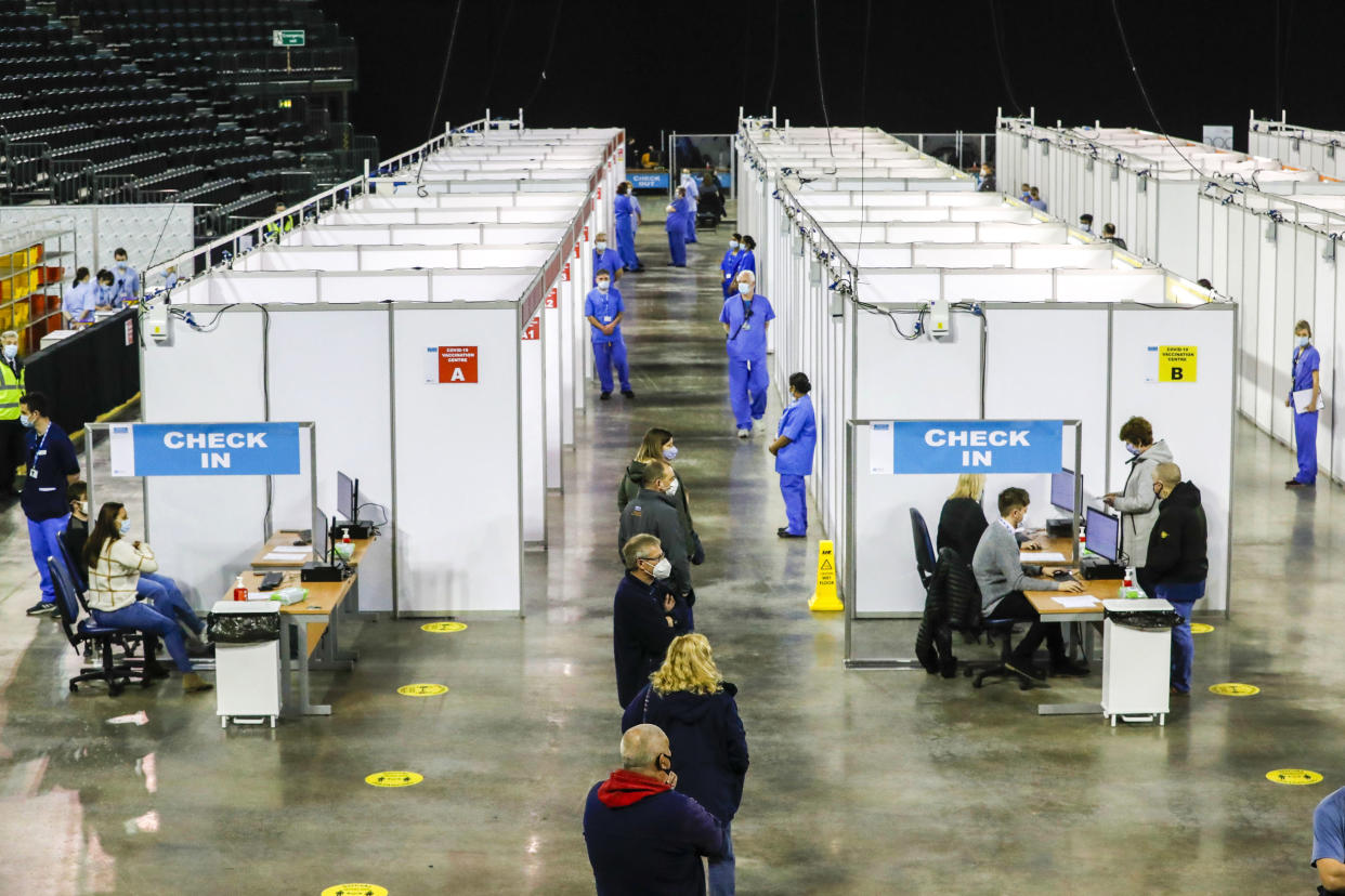 People queue to receive the coronavirus vaccine at the newly opened Covid-19 vaccination centre in the SSE Arena, Belfast, Northern Ireland, Monday March 29, 2021.  The vaccination program continues to increase in an effort to control the spread of COVID-19 virus.(Liam McBurney/PA via AP)