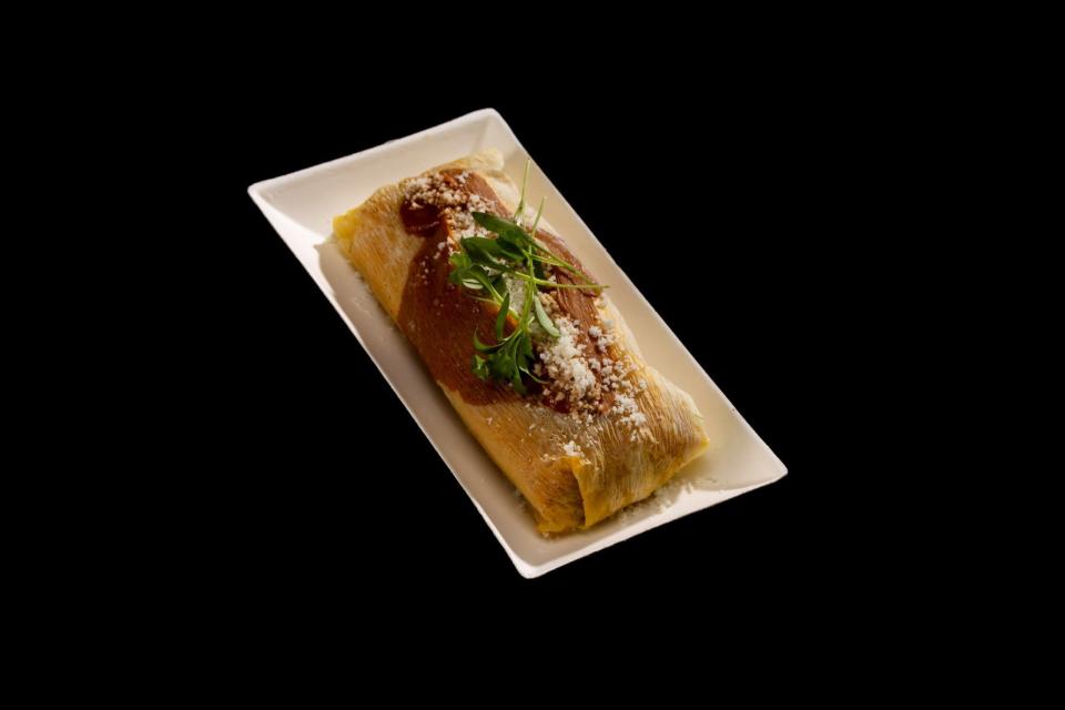Tamales Día de los Muertos (gluten-free): Pork tamales topped with red mole sauce and cotija cheese.