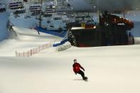 A woman wears a protective face mask as she snowboards at Ski Dubai during the reopening of malls, following the outbreak of the coronavirus disease (COVID-19), at Mall of the Emirates in Dubai