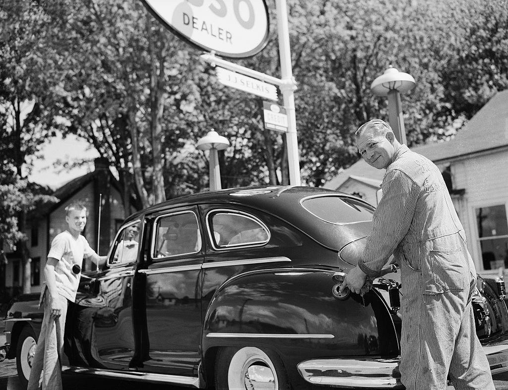 Cape Vincent, NY: Scene at an Esso filling station. An attendant pumps gas into an automobile. Undated photograph, circa 1940's.