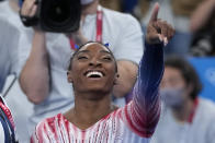 Simone Biles, of the United States, points at teammates on the stands after performing on the balance beam during the artistic gymnastics women's apparatus final at the 2020 Summer Olympics, Tuesday, Aug. 3, 2021, in Tokyo, Japan. (AP Photo/Ashley Landis)