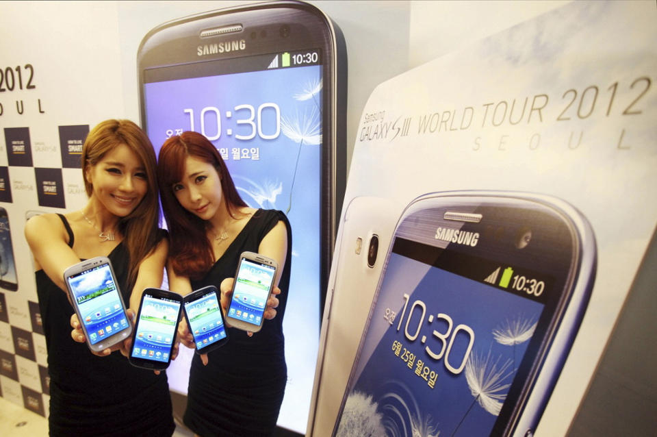 In this photo released by Samsung Electronics Co., models pose with Samsung Electronics' newest smartphone Galaxy S III during its world tour in Seoul, South Korea, Monday, June 25, 2012. Samsung Electronics, the world's top mobile phone maker, said Monday it expects global sales of the latest Galaxy smartphone to surpass 10 million in July even as it struggles to keep up with demand because of component shortages. (AP Photo/Samsung Electronics) NO SALES