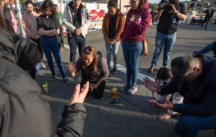 MONTEREY PARK, CA - JANUARY 22: A prayer circle forms at the corner of Garvey Avenue and Garfield Avenue on Sunday, Jan. 22, 2023 near Star Dance Studio where 10 people were killed and 10 injured in a mass shooting Saturday night. (Myung J. Chun / Los Angeles Times)