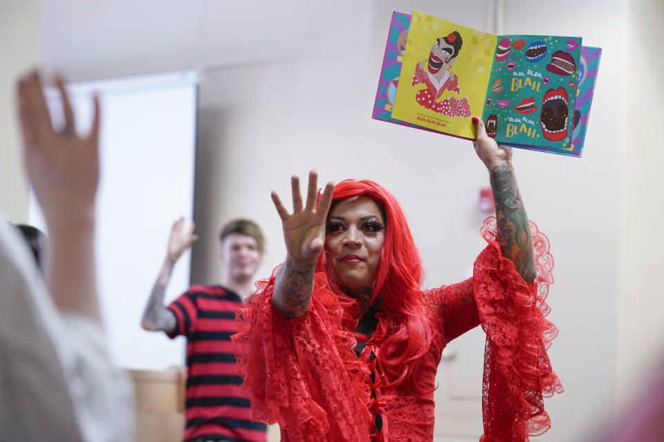 A drag queen who goes by the name Flame reads stories to children and their caretakers during a Drag Story Hour at a public library in New York, Friday, June 17, 2022. (AP Photo/Seth Wenig)