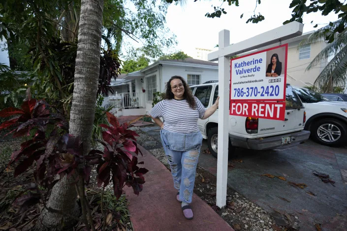 Krystal Guerra, 32, poses for a picture outside her apartment, which she has to leave after her new landlord gave her less than a month's notice that her rent would go up by 26%, Saturday, Feb. 12, 2022, in the Coral Way neighborhood of Miami. Guerra, who works in marketing while also pursuing a degree part-time, had already been spending nearly 50% of her monthly income on rent prior to the increase. Unable to afford a comparable apartment in the area as rents throughout the city have risen dramatically, Guerra is putting many of her belongings into storage and moving in with her boyfriend and his daughter for the time being. (AP Photo/Rebecca Blackwell)