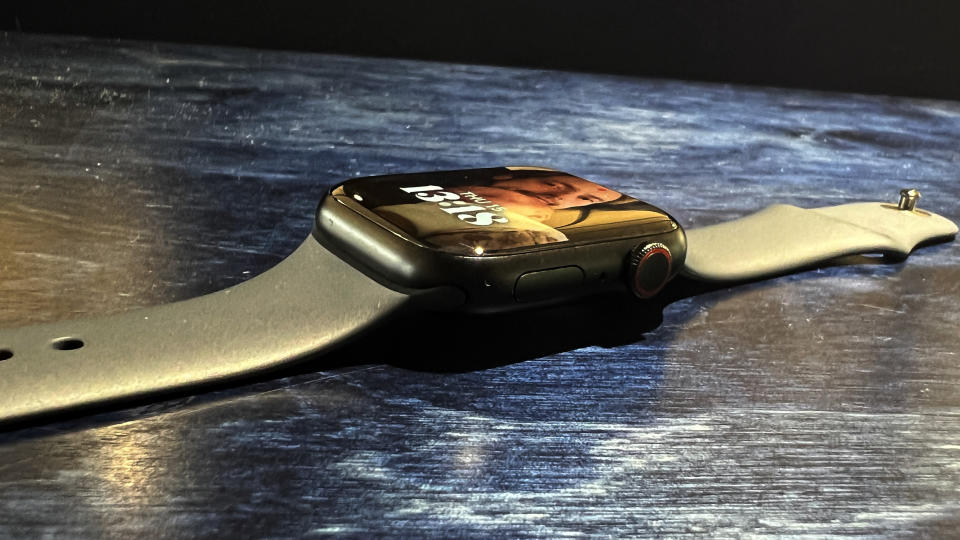 The Apple WAtch 8 on a blue desk and wrist