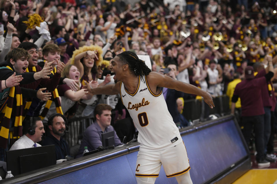 Loyola Chicago's Des Watson celebrates with students after Loyola defeated Dayton 77-72 in an NCAA college basketball game Friday, March 1, 2024, in Chicago. (AP Photo/Paul Beaty)