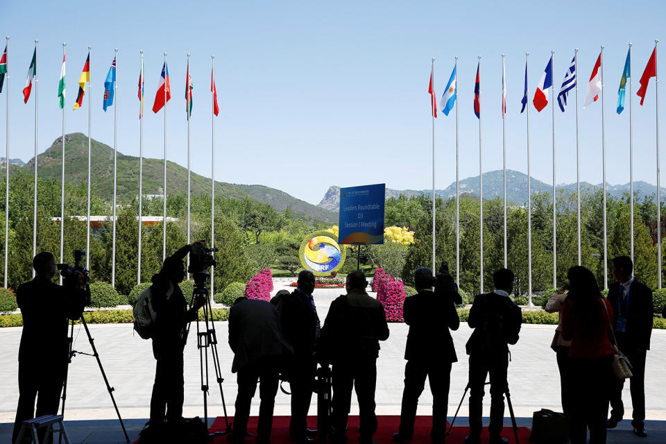 Journalist take pictures outside the venue of a summit in Beijing