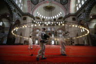 FILE - In this Tuesday, May 26, 2020, file photo, municipality workers disinfect the grounds of the historical Suleymaniye Mosque, in Istanbul, during the third day of Eid el-Fitr and the last day of a four-day curfew due to the coronavirus outbreak. When Turkey changed the way it reports daily COVID-19 infections, it confirmed what medical groups and opposition parties have long suspected — that the country is faced with an alarming surge of cases that is fast exhausting the Turkish health system. The official daily COVID-19 deaths have also steadily risen to record numbers in a reversal of fortune for the country that had been praised for managing to keep fatalities low. With the new data, the country jumped from being one of the least-affected countries in Europe to one of the worst-hit. (AP Photo/Emrah Gurel, File)