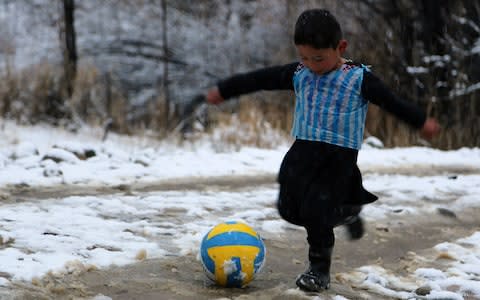 Murtaza in his homemade shirt fashioned from a plastic bag - Credit: AFP