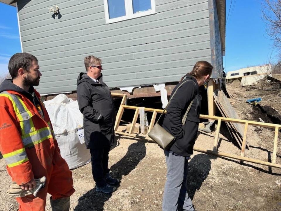 N.W.T. Premier Caroline Cochrane, right, looks at damage caused by flooding in Hay River while visiting the community on Monday.  (Caroline Cochrane/ Twitter - image credit)