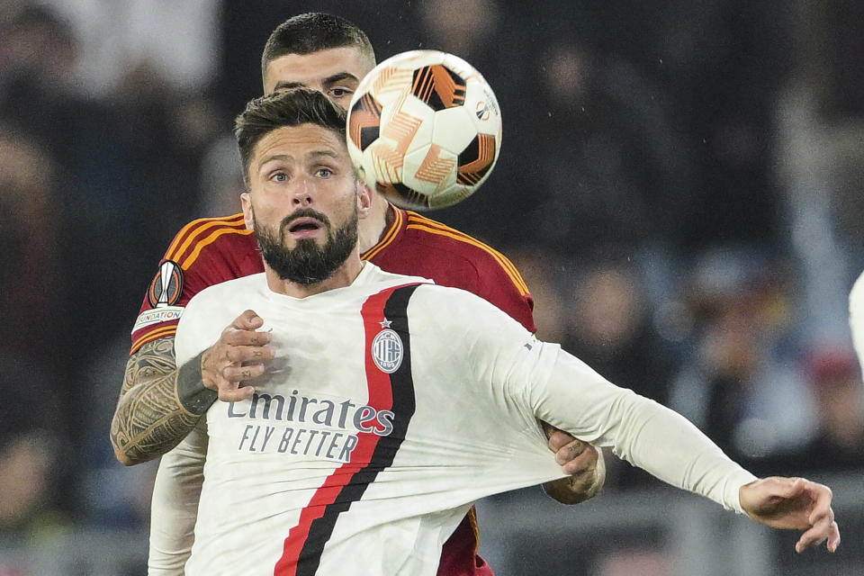 AC Milan's Olivier Giroud, front, fights for the ball with Roma's Gianluca Mancini during the Europa League quarterfinal second leg soccer match between Roma and AC Milan at Rome's Olympic Stadium, Thursday, April 18, 2024. (Alfredo Falcone/LaPresse via AP)