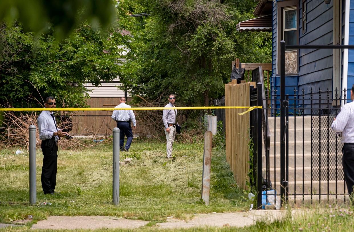 Chicago Police detectives canvass the scene Sunday in the 4800 block of West Iowa Street in the Austin neighborhood of Chicago after an overnight shooting killed one and wounded six people.