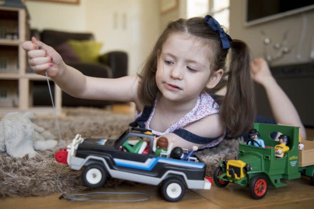 Evie Doherty playing with her toys back home