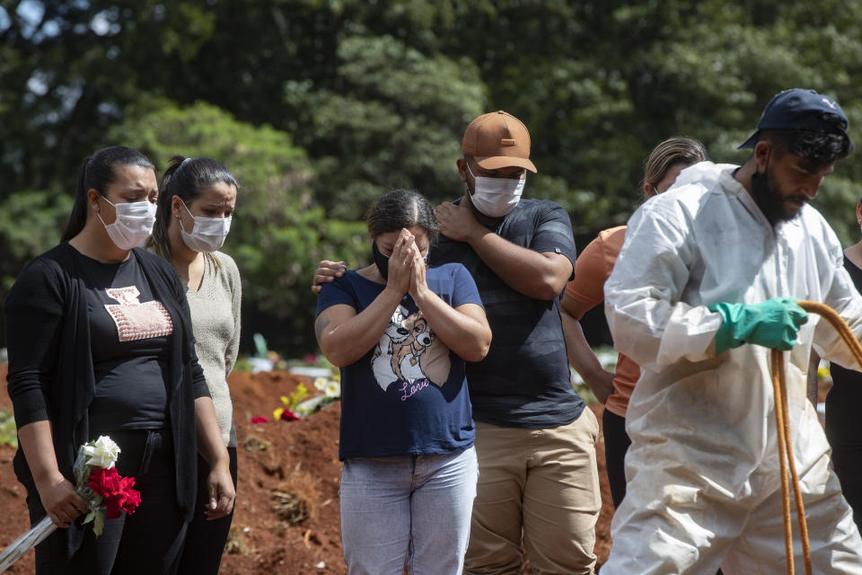 FILE - In this April 7, 2021, file photo, people attend the burial of a relative who died from complications related to COVID-19 at the Vila Formosa cemetery in Sao Paulo, Brazil. Nations around the world set new records Thursday, April 8, for COVID-19 deaths and new coronavirus infections, and the disease surged even in some countries that have kept the virus in check. Brazil became just the second country, after the U.S., to report a 24-hour tally of COVID-19 deaths exceeding 4,000. (AP Photo/Andre Penner, File)