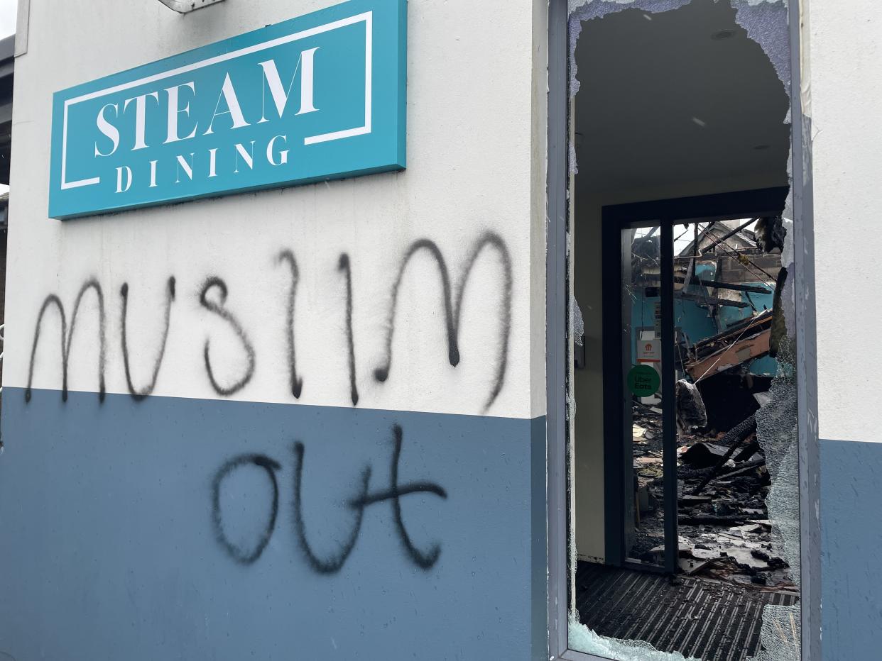 The remains of a bar and restaurant in Newtownabbey following an arson attack which police are treating as hate crime (Rebecca Black/PA)