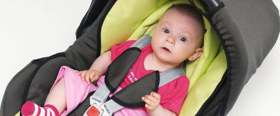 baby in car seat over white