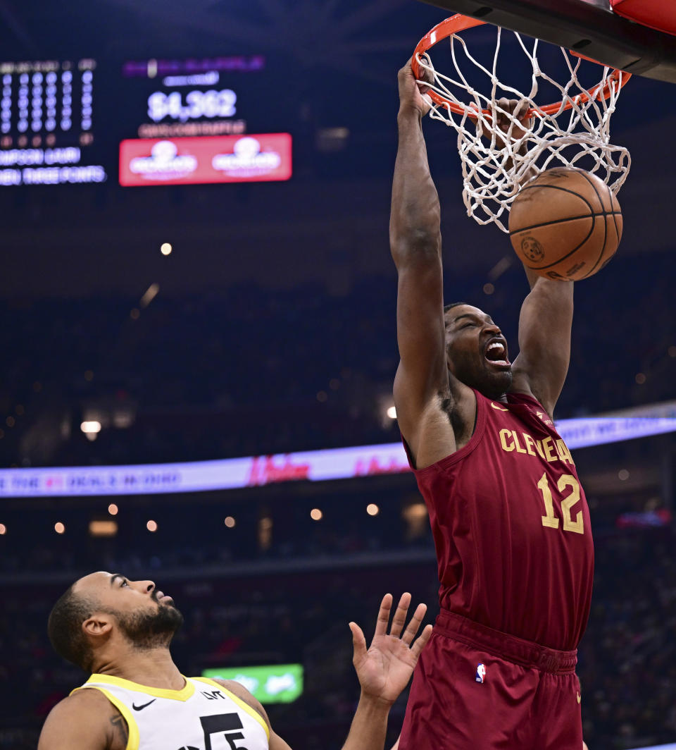 Cleveland Cavaliers center Tristan Thompson dunks over Utah Jazz guard Talen Horton-Tucker during the first half of an NBA basketball game Wednesday, Dec. 20, 2023, in Cleveland. (AP Photo/David Dermer)