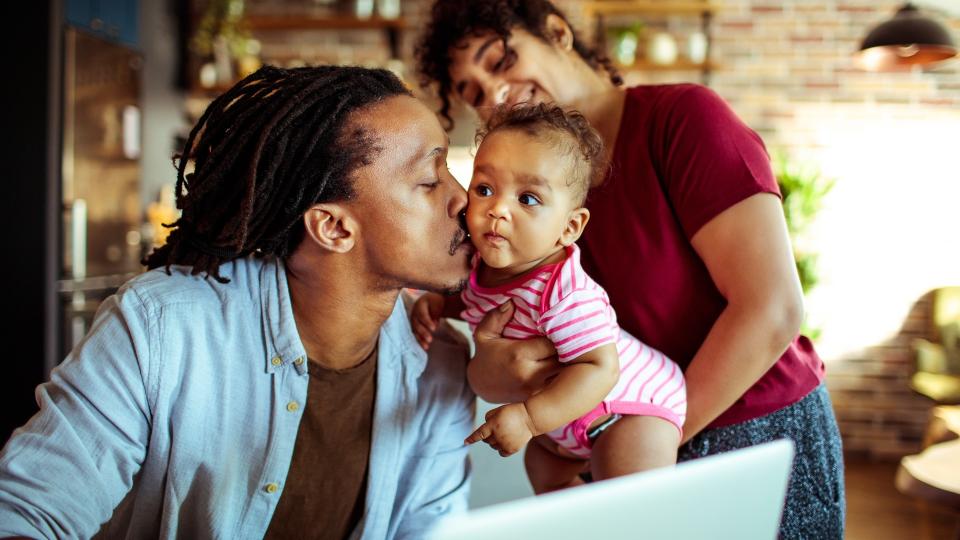 Close up of a young family in their living room using a laptop.