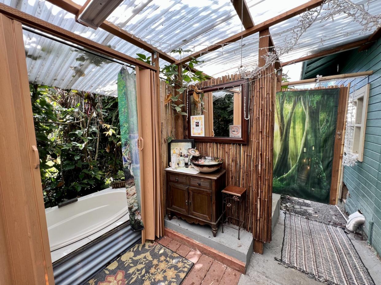 The inside of the bathroom, with tropical decorations and a large bath