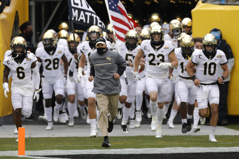 CHARLOTTE, NORTH CAROLINA - DECEMBER 30: Head coach Dave Clawson of the Wake Forest Demon Deacons leads his team onto the field prior to their game against the Wisconsin Badgers in the Duke's Mayo Bowl at Bank of America Stadium on December 30, 2020 in Charlotte, North Carolina. (Photo by Jared C. Tilton/Getty Images)