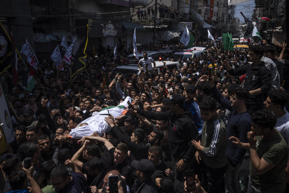 Mourners carry the bodies of Palestinians who were killed in Israeli airstrikes, during their funeral in Gaza City, Tuesday, May 9, 2023. The airstrikes killed three senior commanders of the militant Islamic Jihad group and 10 other people, including two of the commanders' wives, several of their children and others nearby. (AP Photo/Fatima Shbair)