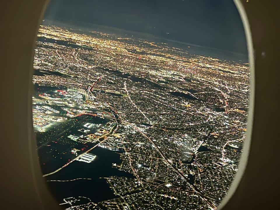 The view out the window of New York after takeoff showing the city lights.