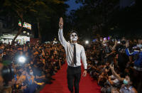 Pro-democracy protesters perform on a mock "red carpet" fashion show billed as a counterpoint to a fashion show being held by one of the monarchy's princesses nearby in Bangkok, Thailand, Thursday, Oct. 29, 2020. The protesters continued to gather Thursday, led by their three main demands of Prime Minister Prayuth Chan-ocha's resignation, changes to a constitution that was drafted under military rule and reforms to the constitutional monarchy. (AP Photo/Gemunu Amarasinghe)