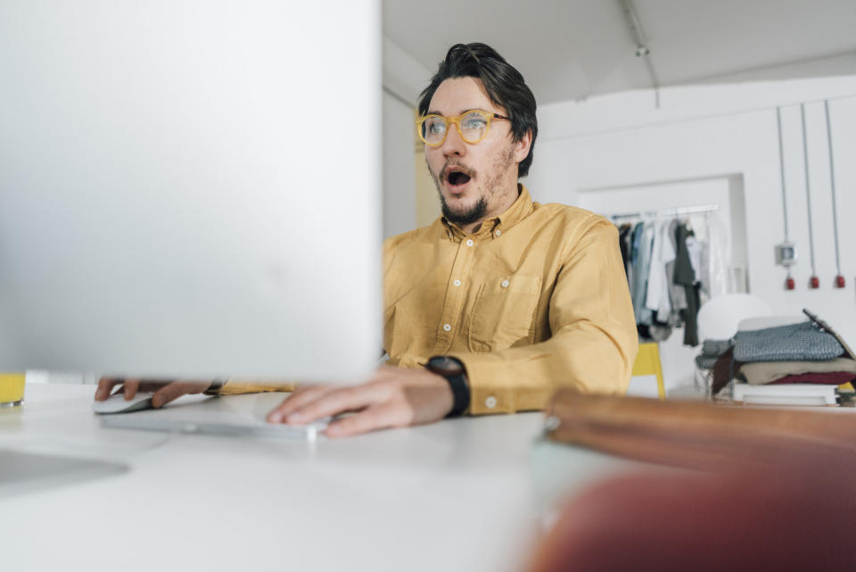 A man looking shocked at his computer