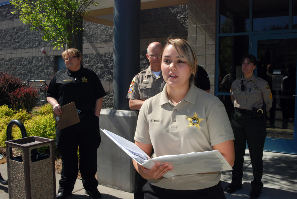 Jospehine County Sheriff's Office spokeswoman Erin Maue speaks to reporters Wednesday, May 30, 2012, outside the entrance to the jail in Grants Pass, Ore. following the release of 39 inmates due to a budget crunch. She said 30 county inmates and 30 held on contract for federal authorities are all the jail can handle due to staffing cuts forced by the failure at the polls of a $12 million law enforcement levy. (AP Photo/Jeff Barnard)