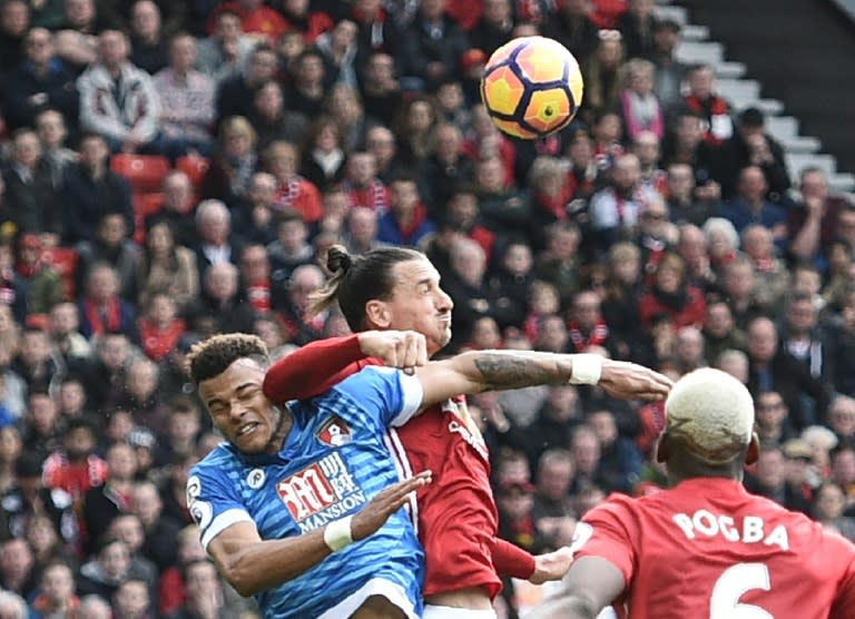 Manchester United's striker Zlatan Ibrahimovic (C) clashes in the air with Bournemouth's defender Tyrone Mings (L) during the English Premier League football match between Manchester United and Bournemouth at Old Trafford on March 4, 2017