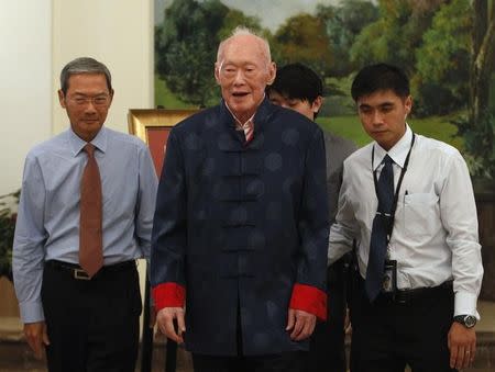 Singapore's former Prime Minister Lee Kuan Yew (C) walks back to his seat after unveiling his new book at the Istana in Singapore August 6, 2013. REUTERS/Edgar Su/Files