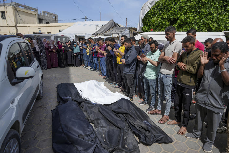 Mourners pray over the bodies of Palestinians who were killed in an Israeli airstrike in Nuseirat, at the Al Aqsa hospital in Deir al Balah, Gaza Strip, Saturday, April 27, 2024. (AP Photo/Abdel Kareem Hana)