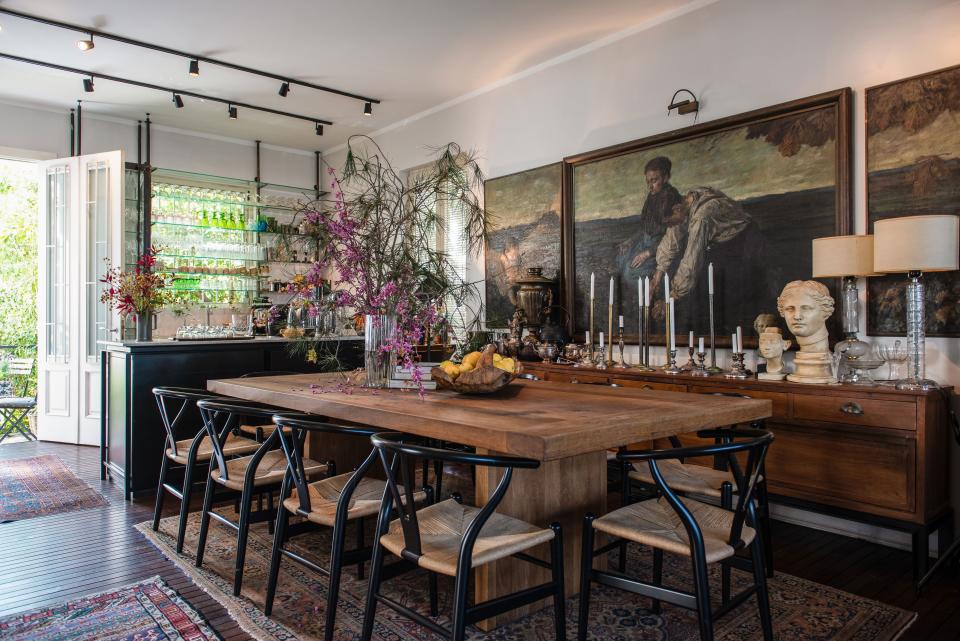 The dining room, with its oak table handcrafted by a local carpenter and Hans Wegner Wishbone Chairs, is the focal point of the house. At the room’s center are a series of three late-18th-century oil paintings by the German artist Hugo Walzer.