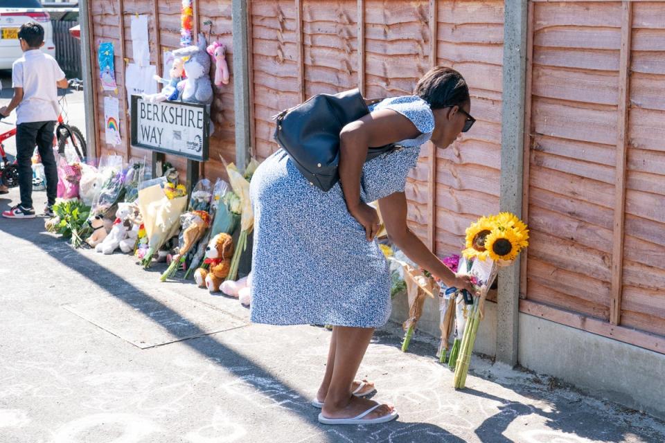 A woman lays flowers near Galpin’s Road in Thornton Heath (Dominic Lipinski/PA) (PA Wire)