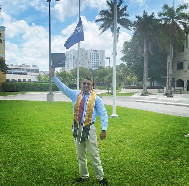 Patrick George poses with a diploma after his graduation from Florida International University.