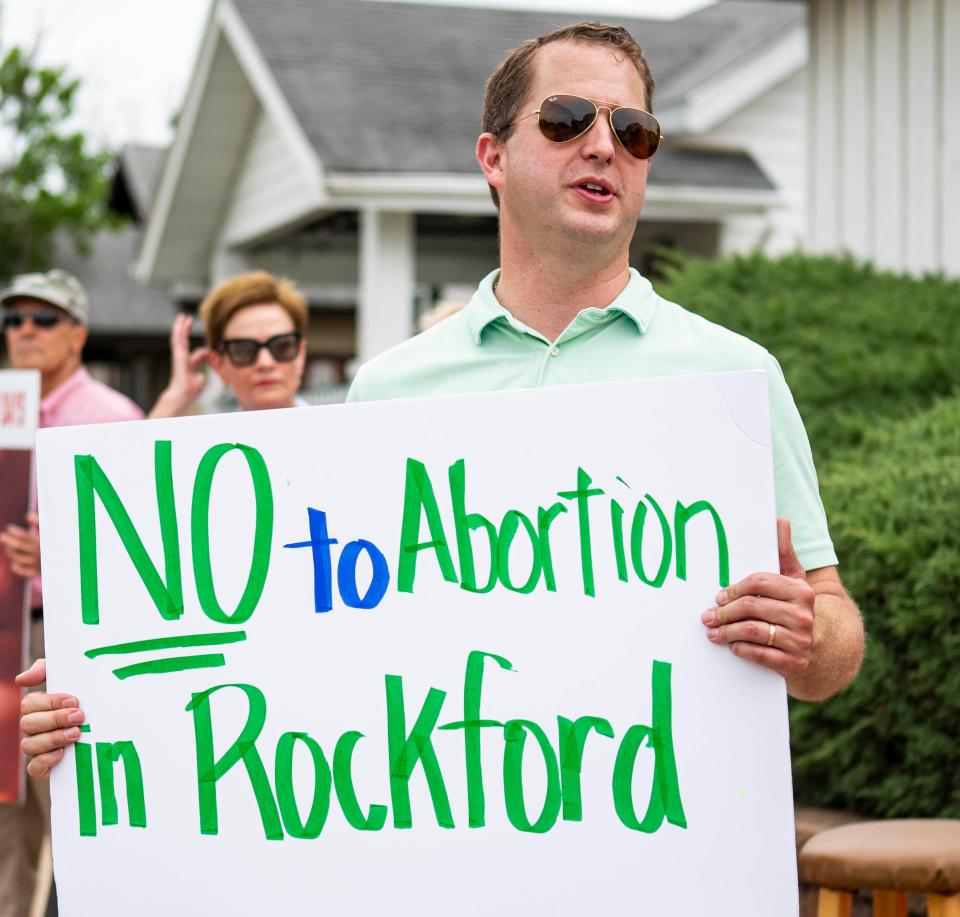 Danniel Pribble holds up a anti-abortion sign on Friday, July 1, 2022, outside 611 Auburn St. in Rockford.