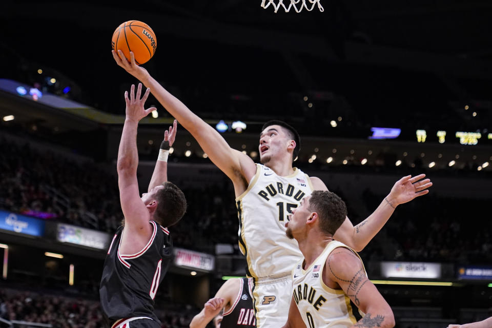 Purdue center Zach Edey (15) grabs a rebound over Davidson guard Foster Loyer (0) in the first half of an NCAA college basketball game in Indianapolis, Saturday, Dec. 17, 2022. (AP Photo/Michael Conroy)