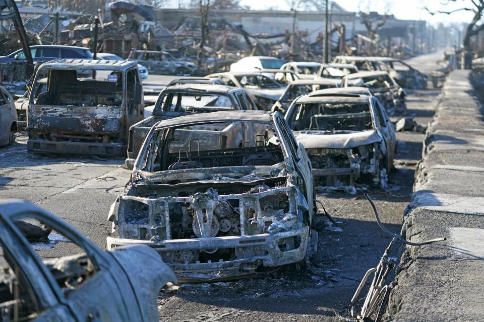 Burnt-out cars line the sea walk after the wildfire on Friday in Lahaina, Hawaii. Hawaii emergency management records show no indication that warning sirens sounded before people ran for their lives from wildfires on Maui that killed multiple people and wiped out a historic town. Instead, officials sent alerts to mobile phones, televisions and radio stations — but widespread power and cellular outages may have limited their reach.