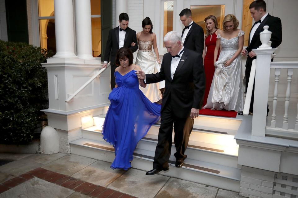 Vice President Mike Pence helps wife, Karen, down the steps of the front porch of the vice presidential residence at the U.S Naval Observatory before heading to the inaugural balls  in Washington, D.C., with their children on Jan. 20, 2017.