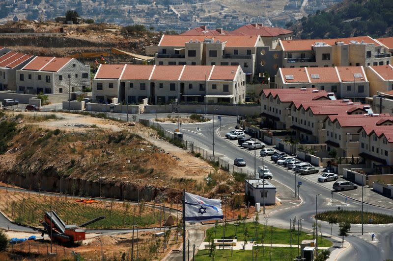 The Israeli national flag flutters as apartments are seen in the background in the Israeli settlement of Efrat in the Israeli-occupied West Bank