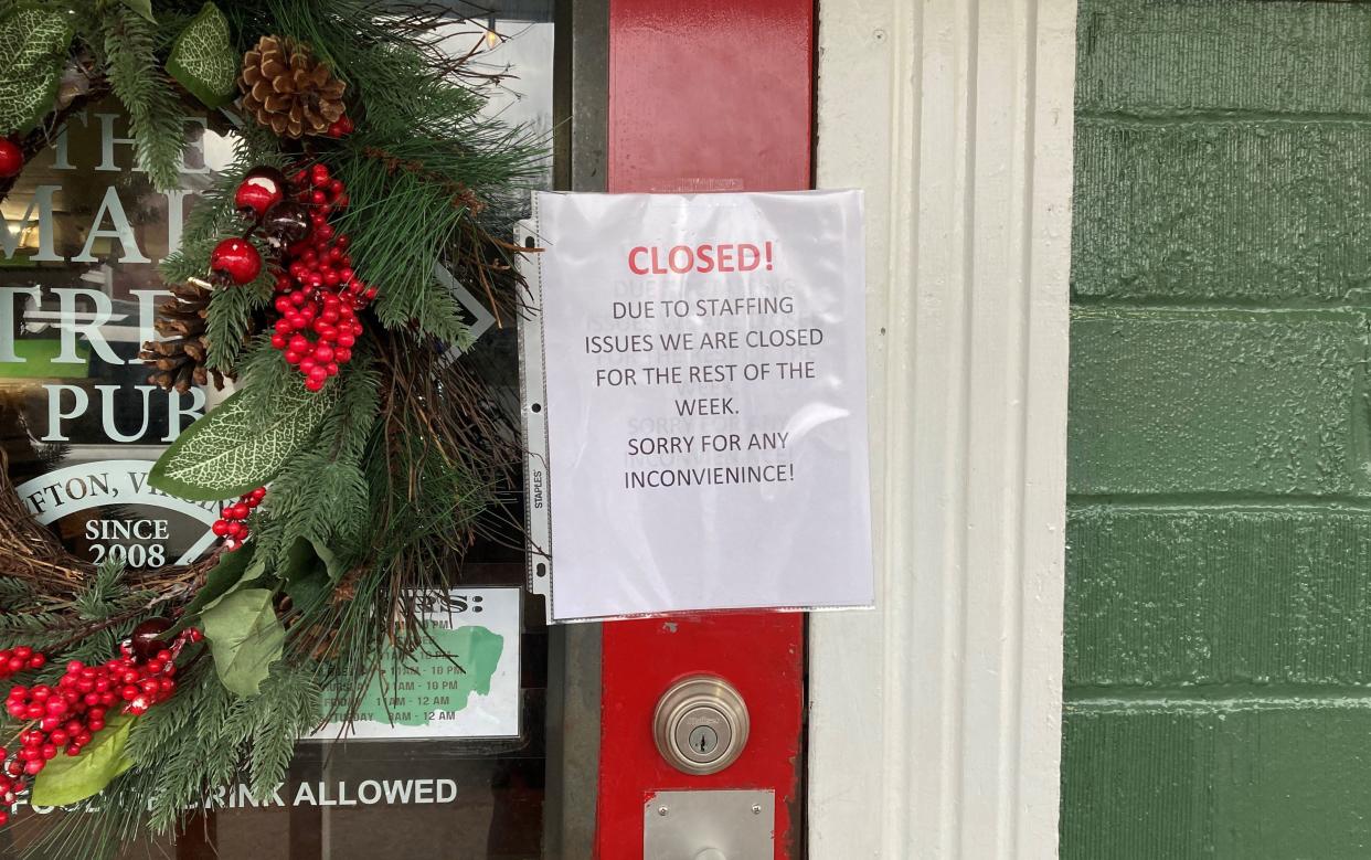 A closed sign is taped to the door of the Main Street Pub in Clifton, Virginia, on December 30, 2021. - The pub has struggled with ongoing staffing issues throughout the pandemic. (Photo by Heather SCOTT / AFP) (Photo by HEATHER SCOTT/AFP via Getty Images)