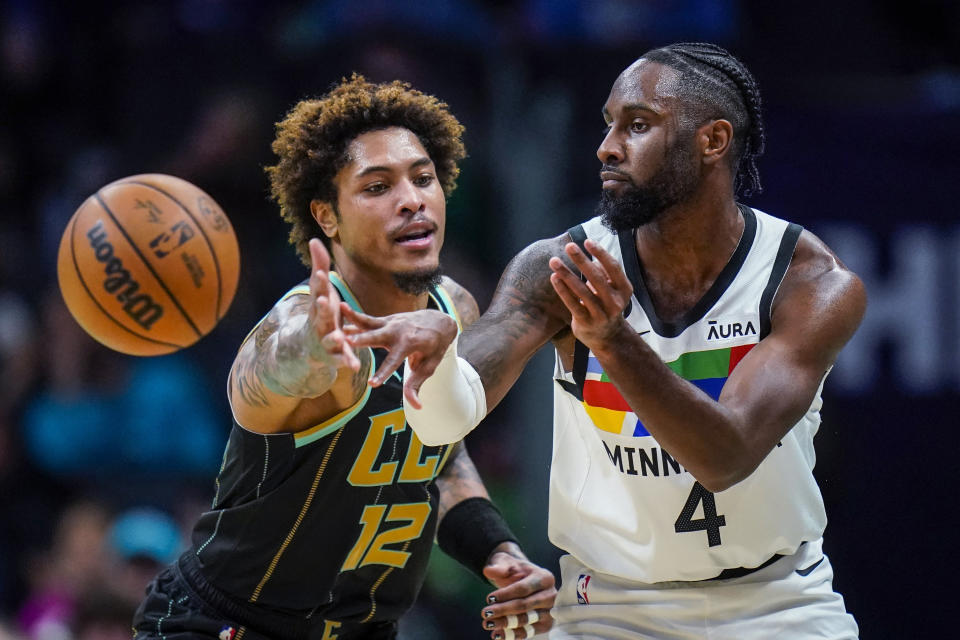 Charlotte Hornets guard Kelly Oubre Jr. (12) defends as Minnesota Timberwolves guard Jaylen Nowell (4) passes the ball during the first half of an NBA basketball game Friday, Nov. 25, 2022, in Charlotte, N.C. (AP Photo/Rusty Jones)