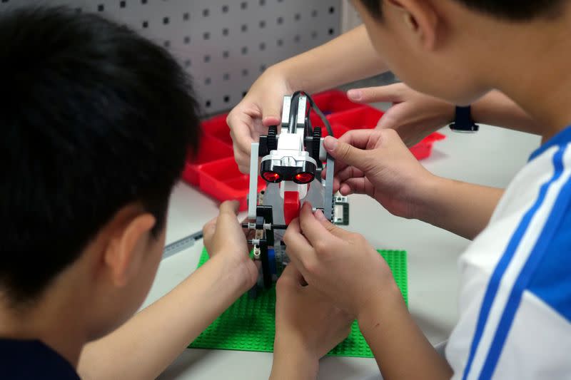 FILE PHOTO: Elementary school students build a motion sensor controlled disinfectant dispenser from Lego parts during a workshop, following a novel coronavirus outbreak, in the southern Taiwanese city of Kaohsiung