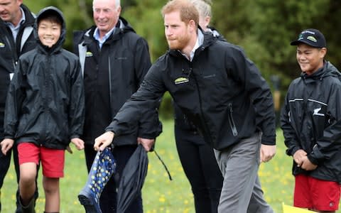 Prince Harry, Duke of Sussex takes part in a wlly boot throwing competition - Credit: AFP